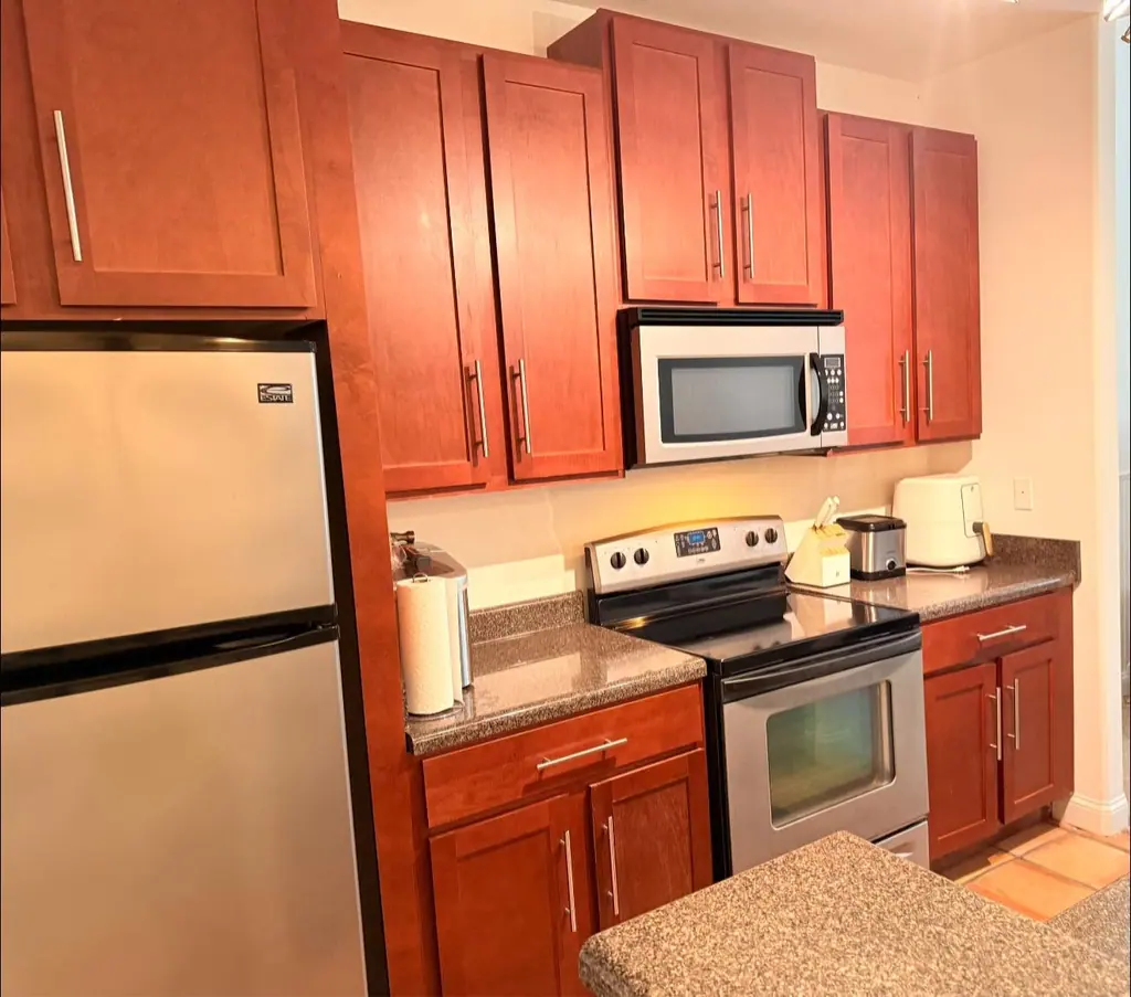 Kitchen with cherry cabinets, granite counters and stainless appliances after a clean